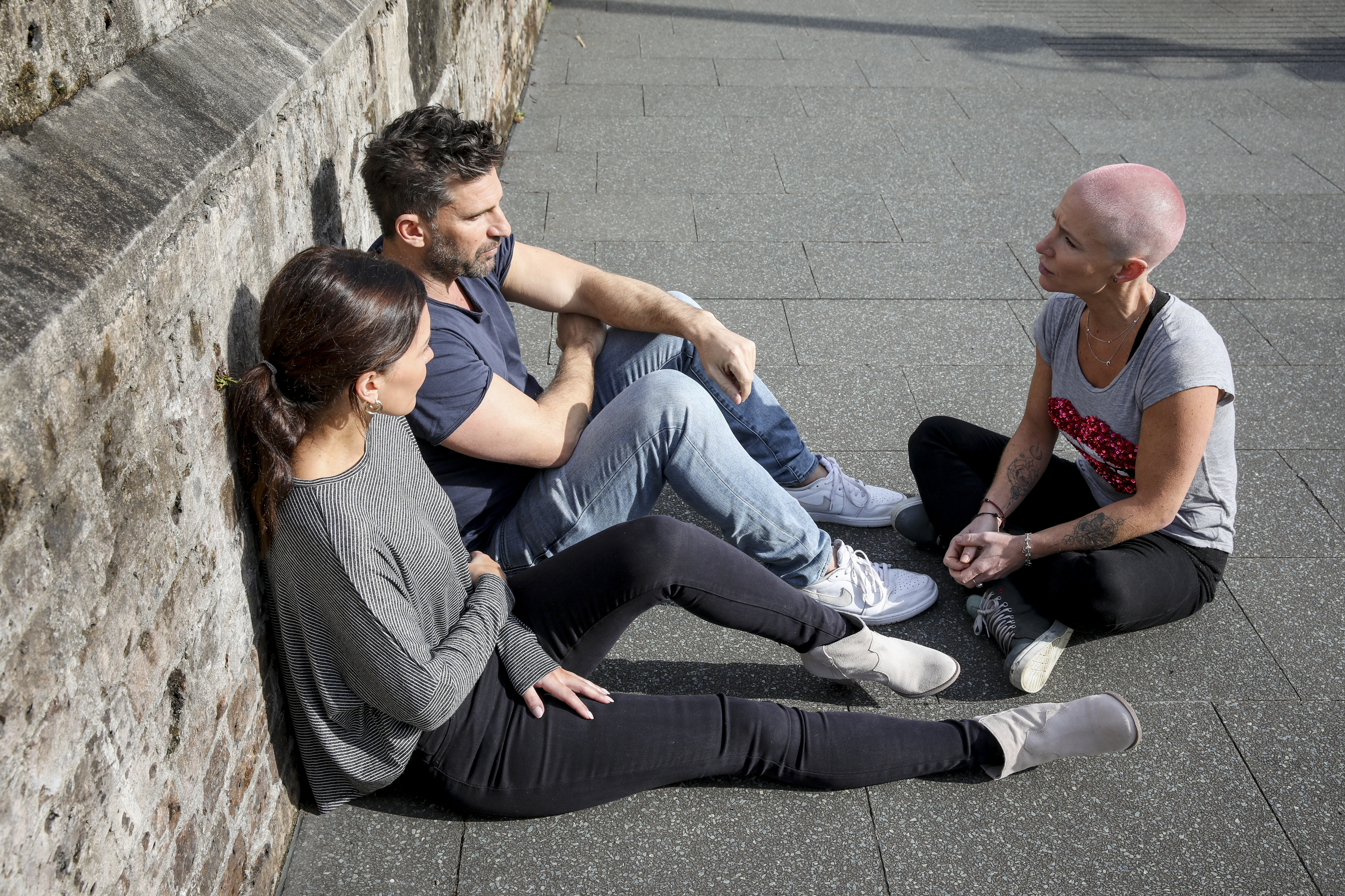 group of people sitting on ground talking