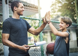 father high five son when playing basketball