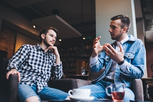 two men talking face to face 