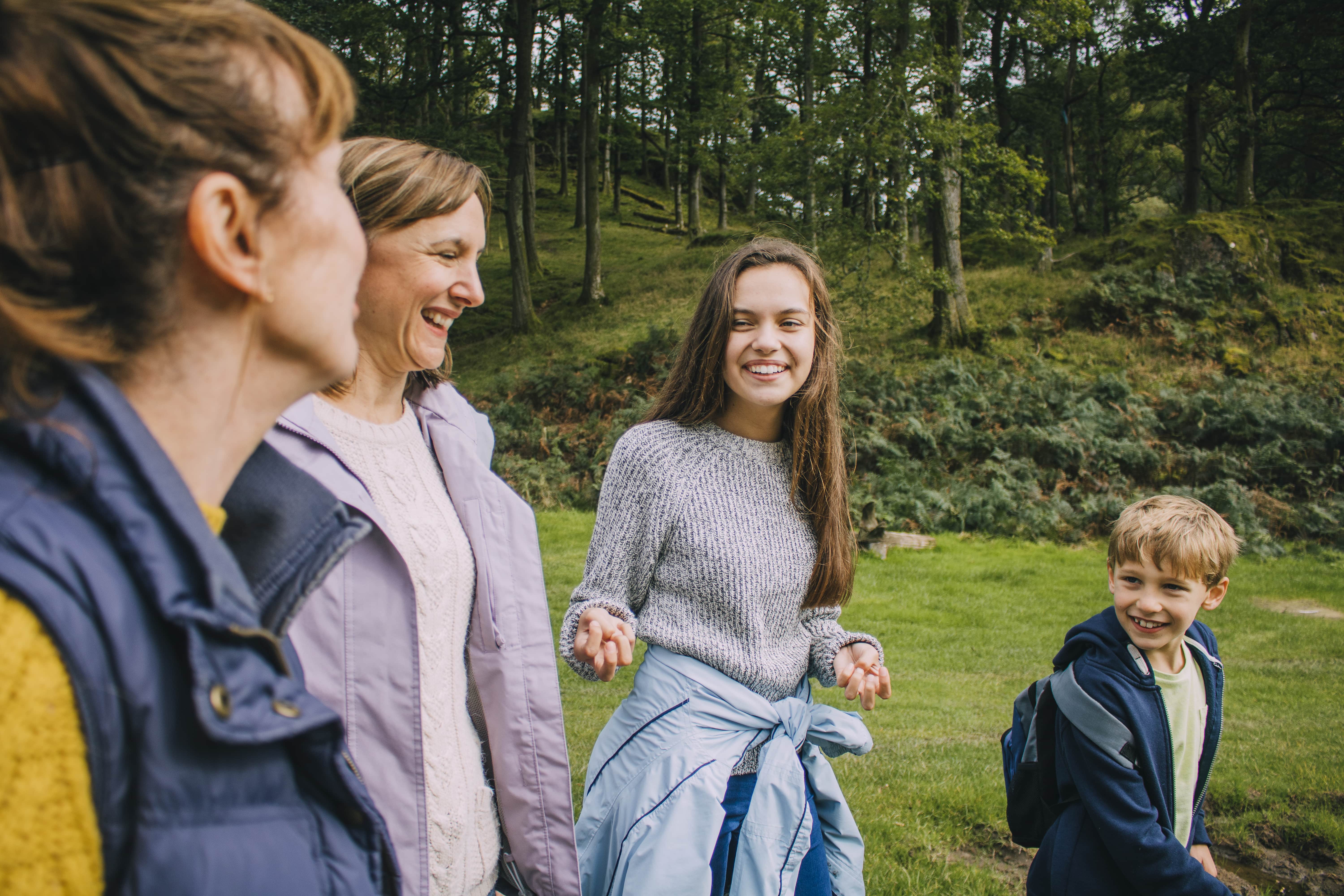 three adult one child walking in wood